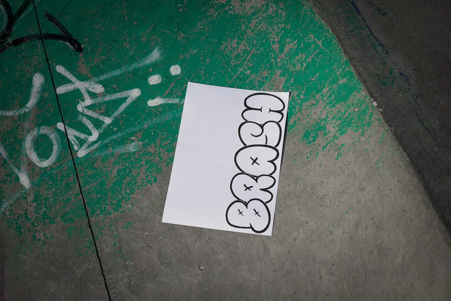 Urban graffiti wall with paper mockup for branding designs, showcasing bubble-style graffiti fonts, ideal for streetwear or edgy projects.